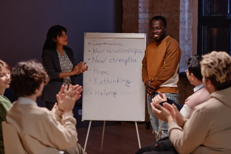 Counselor leading a DBT skills group at a flip chart
