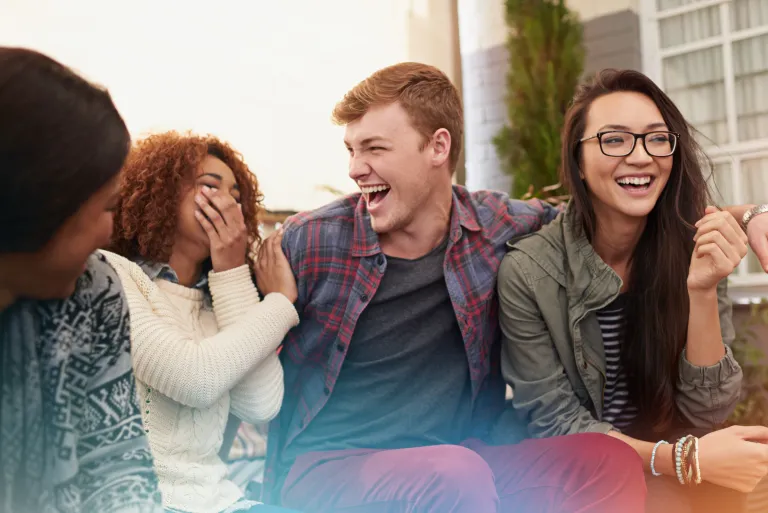 Diverse young adults laughing together in a social confidence group